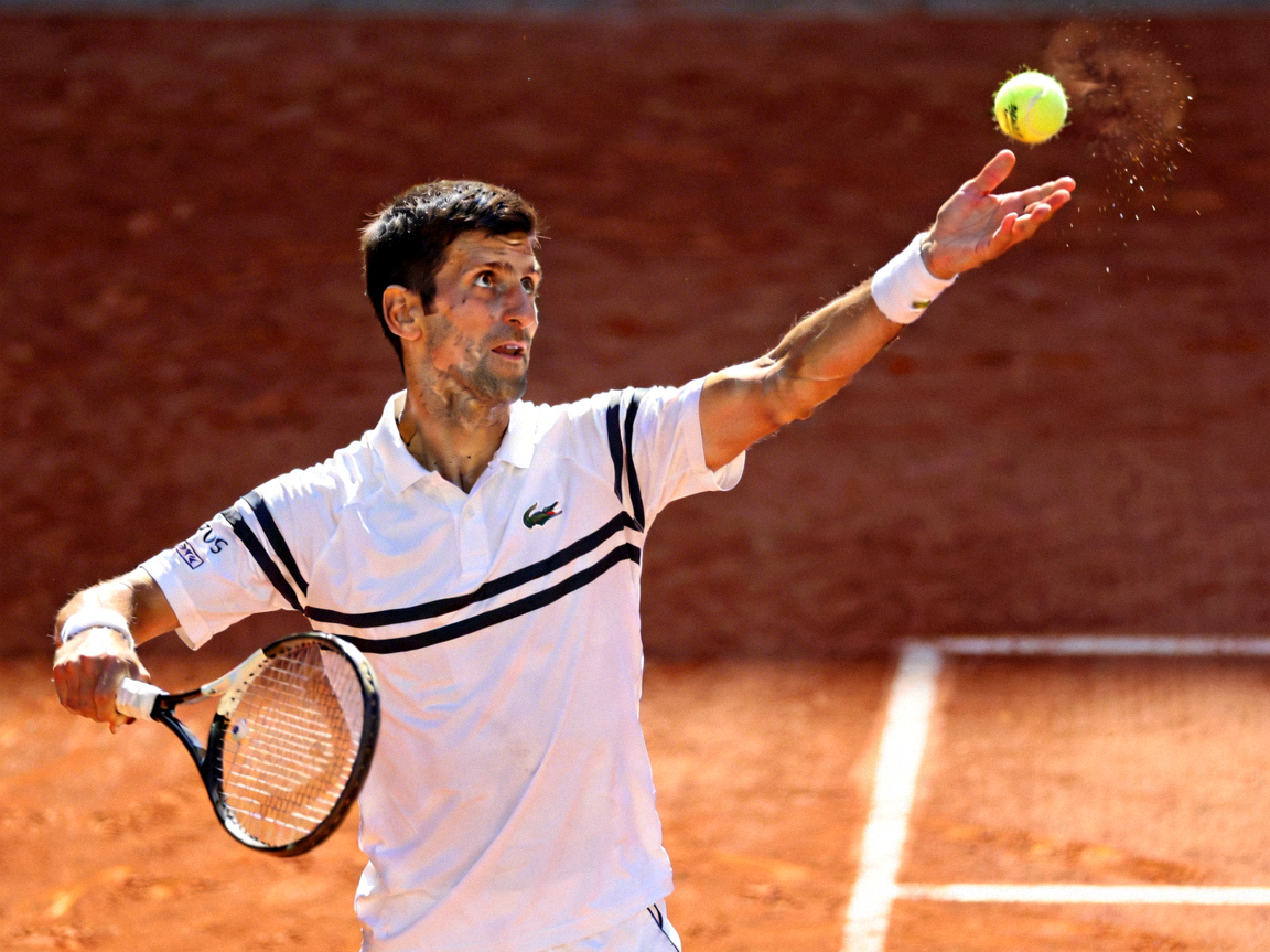 网球运动员诺瓦克·德约科维奇正在发球 - 身着白色运动服